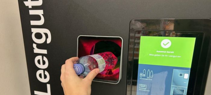 Automat mit Hand, die eine Plastikflasche einwirft